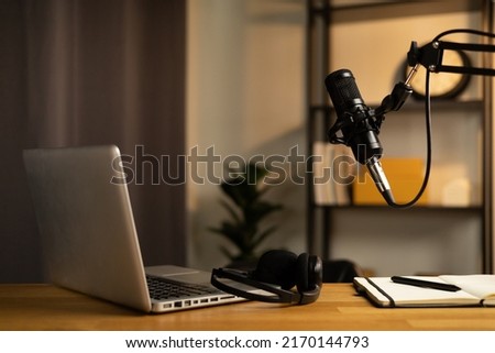 Desk of host streaming radio podcast at home broadcast studio.Such as laptop condenser microphone and headphone on table. Recording host streaming radio podcast interview conversation at home
