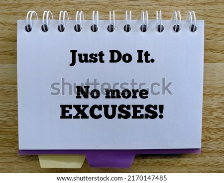 White notebook write with "Just do it. No more excuses!" quote as an inspirational words. Wood pattern as the background. Royalty-Free Stock Photo #2170147485