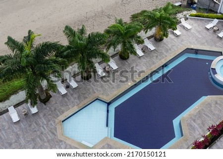 exterior architecture, top perspective of a swimming pool, palm trees, chairs and modern decoration. Resort and hotel in summer, modern lifestyle