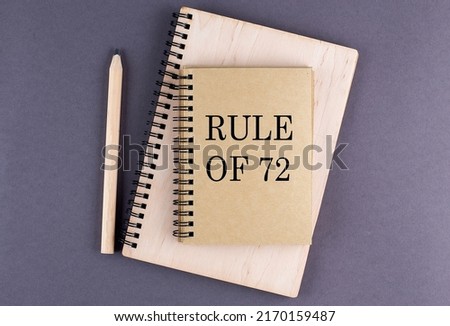 Word RULE OF 72 on a notebook with pencil on the grey background Royalty-Free Stock Photo #2170159487