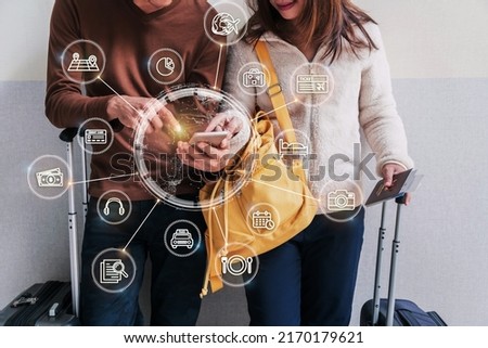 Young couple traveler with baggage and backpack using smartphone for finding information and planning trips at the airport, Travel planning concept with icons and diagram Royalty-Free Stock Photo #2170179621