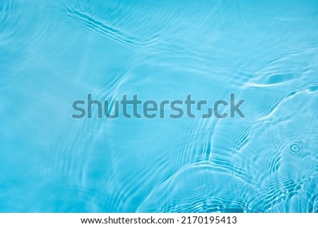 Transparent blue clear water surface texture with ripples, splashes and bubbles. Abstract nature background Water waves in sunlight. Cosmetic moisturizer micellar toner emulsion. Top view, copy space Royalty-Free Stock Photo #2170195413