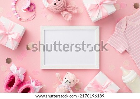 Baby girl concept. Top view photo of photo frame gift boxes shirt shoes knitted bunny rattle toy teddy-bear soother chain milk bottle and confetti on isolated pastel pink background with empty space