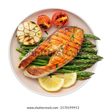 Plate of grilled trout steak and asparagus with ingredients isolated on white background. Top view Royalty-Free Stock Photo #2170199913