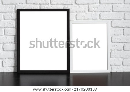 Blank picture frame against  brick wall with copy space for your design