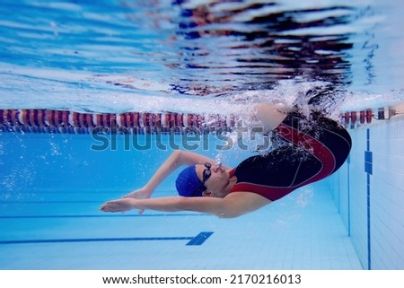 Woman in swimming pool . Underwater photo
