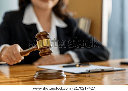 businesswoman or lawyer woman hands knocking hammer judge scales and paper at office desk legal work.