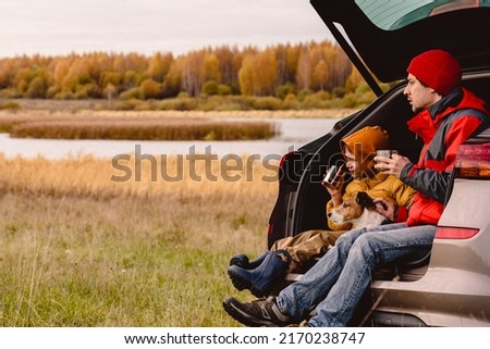 Family traveling by car having rest and looking at beautiful Fall landscape Royalty-Free Stock Photo #2170238747