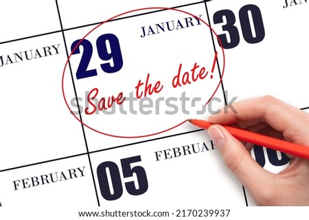 29th day of January. Hand drawing red line and writing the text Save the date on calendar date January 29.  Winter month, day of the year concept.