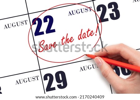 22nd day of August. Hand drawing red line and writing the text Save the date on calendar date August 22.  Summer month, day of the year concept.