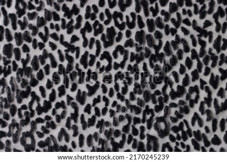 Top view of leopard wrinkled smooth black cloth seamless pattern background. Dark transparent fabric mesh with animal print background