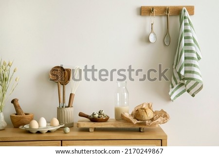 Interior design of kitchen space with rattan commode, milk, eggs, food and kitchen accessories in boho home decor.  Template. 