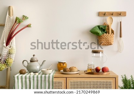 Interior design of kitchen space with rattan commode,  ladder, rhubarb, vegetables, food and kitchen accessories in modern home decor.  Template. 