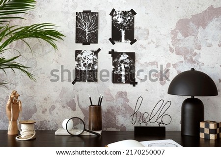 Concrete interior of home office with black desk, office accessories, image. Rack with personal accessories. Home decor. Template. 