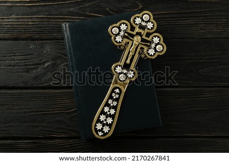 Cross on Bible on wooden background, top view