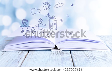 Open book with paintings on bright background