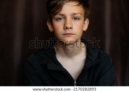 Portrait of blonde teenage boy on dark background outdoor. Low key close up shot of a young teen boy, adolescence. Selective focus. Loneliness, sadness, adolescent anxiety, emotional. Royalty-Free Stock Photo #2170282893