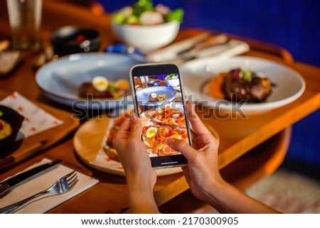 Food photography of salmon toast of lunch or dinner in luxury restaurant. Influencer makes food photography for social networks with phone.