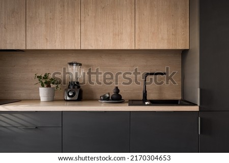 Wooden kitchen countertop with black sink and tap and decorations