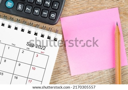 The Blank sticky note on September 2022 desk calendar on wooden background for your text. Royalty-Free Stock Photo #2170305557
