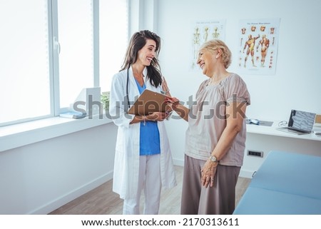 A senior woman is indoors in a hospital room. She is watching her female doctor using a tablet computer. She is explaining a medication schedule to her. Patient and doctor talking 