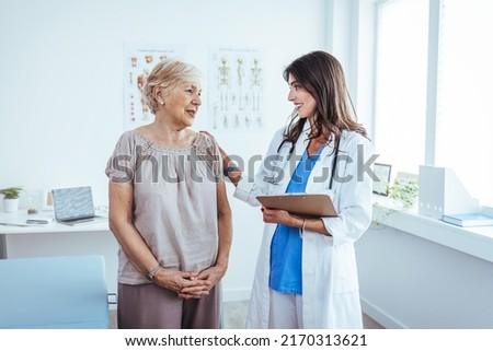 Senior woman having a consultation with her doctor. Senior woman having a doctors appointment. Doctor in blue uniform and protective face mask giving advice to Senior female patient at hospital