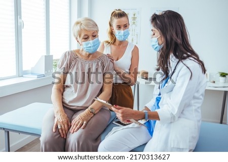 Senior woman and adult daughter with female doctor. Professional smiling doctor meeting a senior patient and her daughter at the hospital, medical service concept