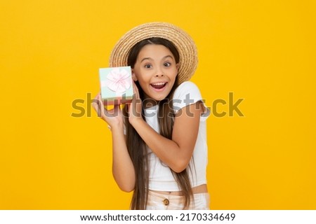 amazed teen child hold present box on yellow background