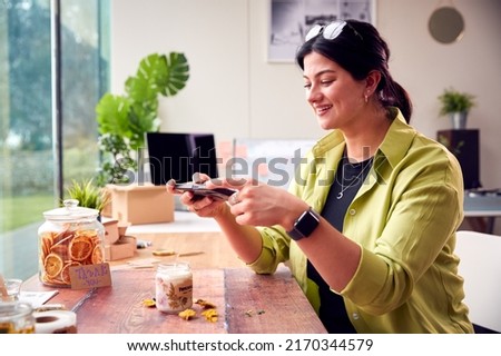 Woman Running Online Business Making Boutique Candles Taking Photos For Marketing With Mobile Phone