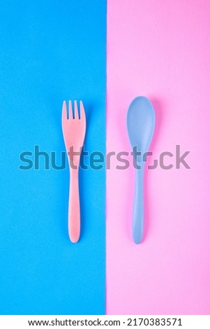 Pink fork and blue spoon on two colored background. Flat lay with reusable utensils made of wheat straw Royalty-Free Stock Photo #2170383571