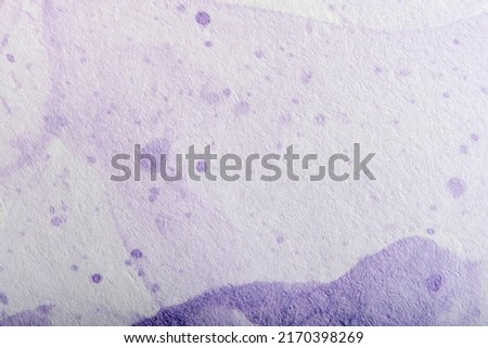 Violet background, textured paper painted and splashed with purple paint in an abstract composition with copy space using the trend color very petri.
