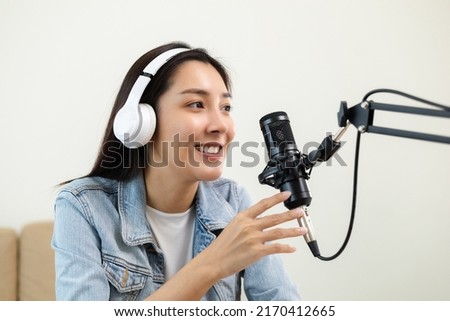 Content creator woman host streaming her a podcast on laptop with headphones and microphone interview cheering guest conversation at broadcast studio. Blogger motivation recording voice over radio.