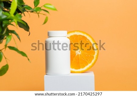 Medicine bottle of vitamins or pills with sliced orange, vitamin C, multivitamin natural supplement, bottle mockup Royalty-Free Stock Photo #2170425297