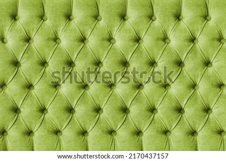 Green capitone checkered soft fabric textile decorative background with buttons. Classic retro Chesterfield style, luxurious upholstery buttoned texture for furniture, wall, headboard, sofa, couch Royalty-Free Stock Photo #2170437157