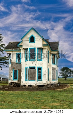 Old Wooden abandoned decaying white house and blue sky and clouds. Royalty-Free Stock Photo #2170441039
