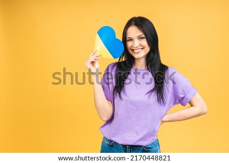 Portrait of nice beautiful lovely glad cheerful woman holding in hands Ukrainian flag having fun isolated over yellow pastel color background.