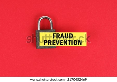 Business and security concept. On the red surface there is a lock with a sticker with the inscription - Fraud prevention