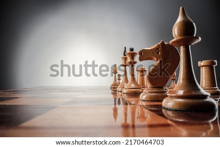 Chess board game competition concept of business ideas and strategy ideas concept. Chess figures on a wood polish board on a  dark grey  background 