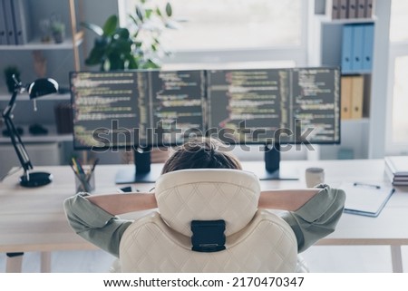 Rear behind photo of skilled web designer sitting chair hands behind head rest relax office workplace