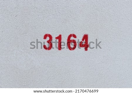 Red Number 3164 on the white wall. Spray paint.
