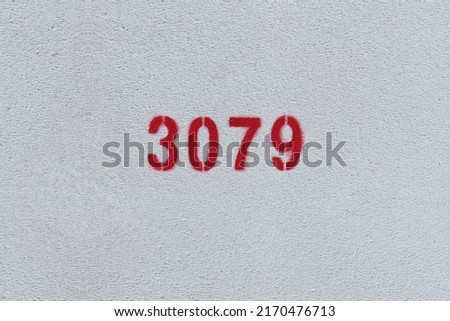 Red Number 3079 on the white wall. Spray paint.
