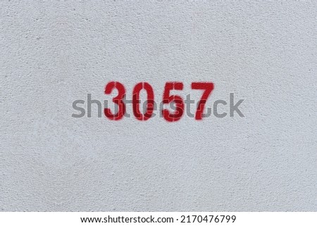 Red Number 3057 on the white wall. Spray paint.
