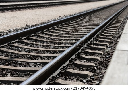 Photo of railroad tracks running diagonally through the picture with partially visible platform as concept for direction travel sadness and loneliness Royalty-Free Stock Photo #2170494853