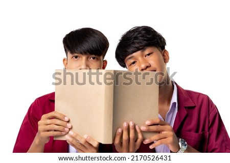 Male homosexual couple happy hides his face behind a book over white background. Two young male students in uniform holding books on white