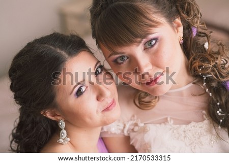 Bride and bridesmaid. A party of stylish women's group in elegant dress celebrating, partying, a wedding. Two beautiful girls pose for the camera. beautiful makeup