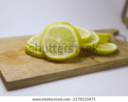 a slices and stack of group yellow lemon or lime to make lemonade on wood isolated with white background