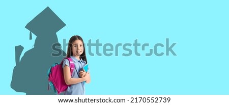 Cute Asian schoolgirl dreaming about higher education on blue background with space for text