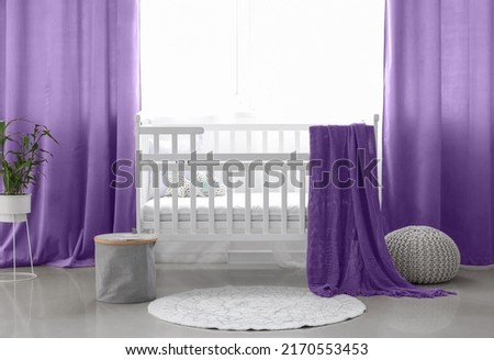Interior of stylish children's room with comfortable crib near window with beautiful curtains