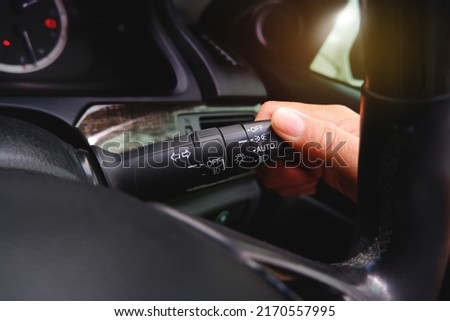 Driver hand turns the headlight switch lever on