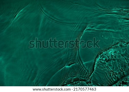 Transparent dark green clear water surface texture with ripples, splashes. Abstract nature background Water waves in sunlight with copy space, top view. Cosmetic moisturizer micellar toner emulsion Royalty-Free Stock Photo #2170577463